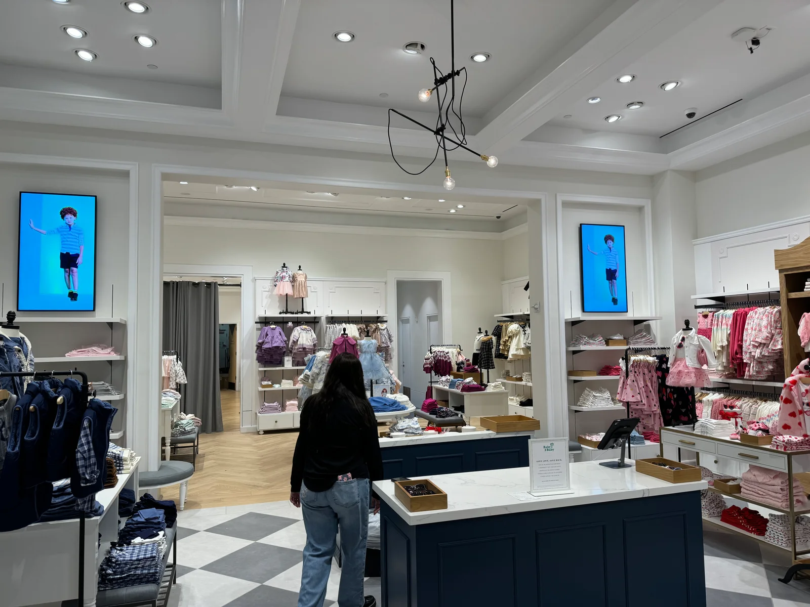 Indoor CrownTV digital signage display inside a Janie and Jack retail location.